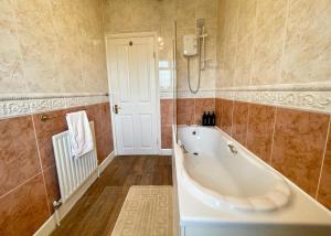 ein Badezimmer mit Badewanne und Dusche in der Unterkunft Cosy Croft Cottage in Greasbrough + 24 Fotos