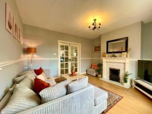 Cosy Croft Cottage في Greasbrough: غرفة معيشة مع أريكة ومدفأة