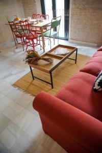 ein Wohnzimmer mit einem roten Sofa, einem Tisch und Stühlen in der Unterkunft San Diego Cathedral Sevilla in Sevilla