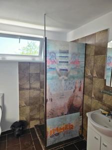 uma casa de banho com um chuveiro e um lavatório. em Traflor Termhouse em Venus