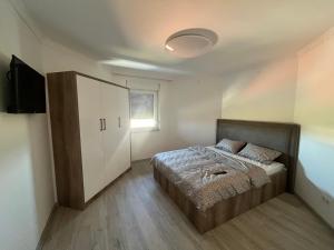 ein Schlafzimmer mit einem Bett und einem weißen Schrank in der Unterkunft Villa Diamond in Bijeljina
