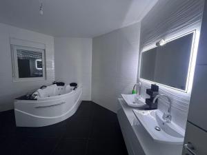 un bagno bianco con vasca e lavandino di Villa Diamond a Bijeljina