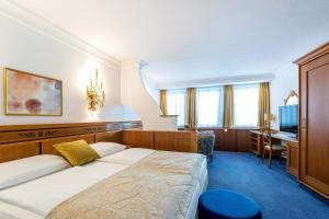 Habitación de hotel con cama y escritorio en Hotel Mondschein en Innsbruck