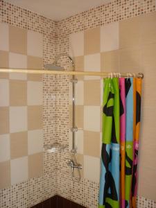 a shower with a shower curtain in a bathroom at Marigolds in Sigulda