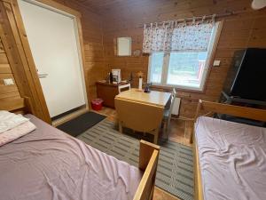 een slaapkamer met een bureau, een bed en een tafel bij Porotila Toini Sanila in Sevettijärvi
