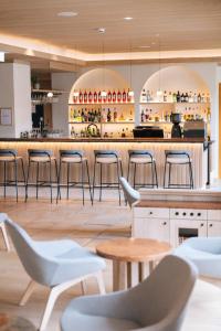 un bar dans un restaurant avec des chaises et des tables dans l'établissement POST Family Resort, à Unken