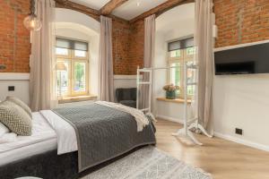 a bedroom with a bed and a brick wall at Biała 16 in Bielsko-Biała