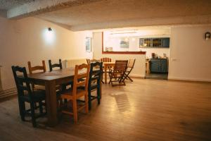 a dining room and kitchen with a table and chairs at Turnul Maresalului in Corbeni