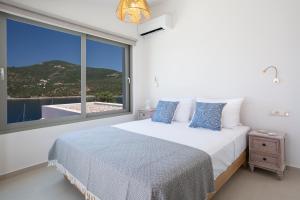 a bedroom with a bed and a large window at Villa Sophia-Private Sea Access in Marantochori