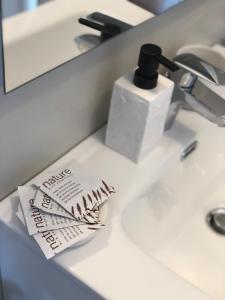 ein Waschbecken im Bad mit Papier auf der Theke in der Unterkunft Canevon Suite Apartment in Bardolino