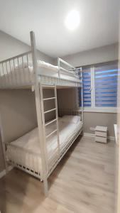 a bedroom with two bunk beds and a window at Apartamenty Tuwima in Piechowice