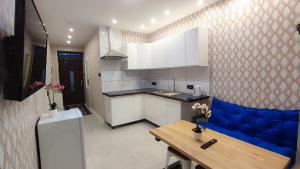 a kitchen with a blue couch in a room at Apartamenty Tuwima in Piechowice