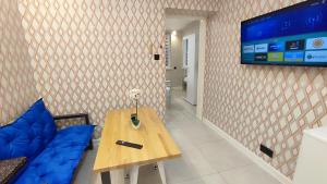 a room with a table and a tv on a wall at Apartamenty Tuwima in Piechowice