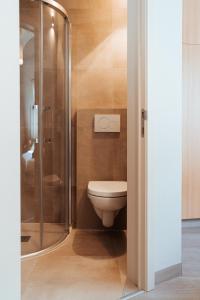 a bathroom with a toilet and a glass shower at Hotel Brasserie De Beiaard in Torhout