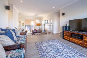 a living room with a couch and a flat screen tv at The Halfway House @ Kingswood Golf Estate in George