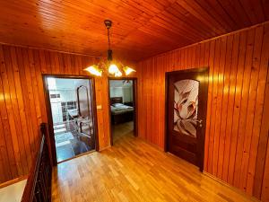 a hallway with wood paneled walls and a wooden door at Spacious, 3BD home in Radauti in Rădăuţi