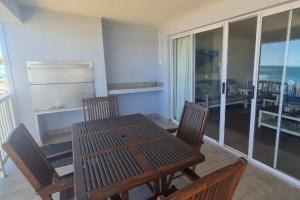 a dining room with a table and chairs and a balcony at Point Village Accommodation - Linda in Mossel Bay +13 photos
