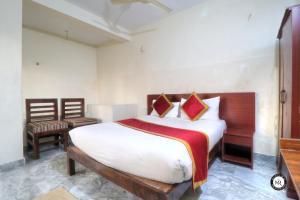 ein Schlafzimmer mit einem Bett und einem Stuhl in der Unterkunft Coorg Avani Holiday Inn in Madikeri