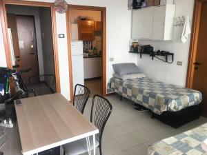 a room with a table and a bed and a kitchen at Milan White Tower Flat in Milan