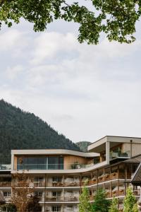 ein Gebäude mit einem Berg im Hintergrund in der Unterkunft POST Family Resort in Unken