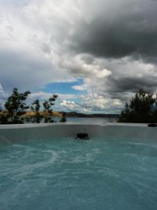 een zwembad gevuld met water onder een bewolkte hemel bij Infinity in Šibenik