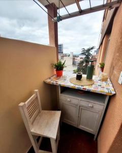balcón con mesa, silla y ventana en ALTOS JUJUY ALQUILER TEMPORARIO en San Salvador de Jujuy