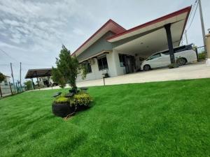 a house with a car parked in a yard at S99 HOMESTAY KUDAT in Kudat