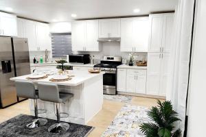 una cucina con armadi bianchi e piano di lavoro bianco di The Heart Of LA House a Los Angeles