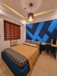 een slaapkamer met een groot bed met een blauwe muur bij Legarse Staycation at Montecito Residential Resort in Manilla