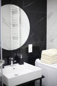 ein Badezimmer mit einem weißen Waschbecken und einem Spiegel in der Unterkunft Authentic and Spacious flat in Jelenia Gora in Jelenia Góra