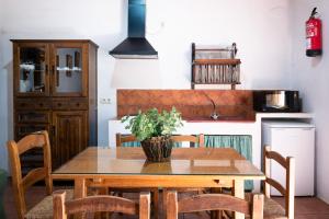 a kitchen with a wooden table with chairs and a kitchen at Bungalows Camping Jimmy Jones in Villaviciosa de Córdoba