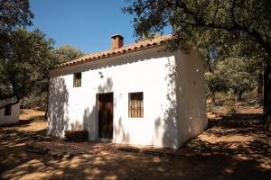 a white house with a tree in front of it at Bungalows Camping Jimmy Jones in Villaviciosa de Córdoba