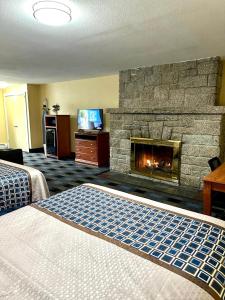 a hotel room with a fireplace and a bed at Swiss Chalets Village Inn in North Conway