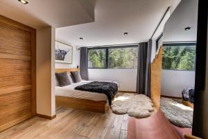 a bedroom with a bed and two windows at Black Pearl in Chamonix-Mont-Blanc +26 photos