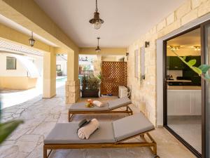 a patio with two lounge chairs and a kitchen at Jasmine Dreams 1bed Apt Wpool in Kouklia