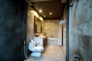 uma casa de banho com um WC, um lavatório e uma banheira em The Citta Luxury Residence em Seminyak