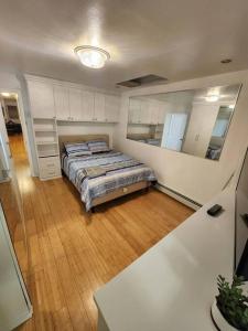 1 dormitorio con cama y espejo grande en Cosy Modern Home Mins to NYC! en Union City