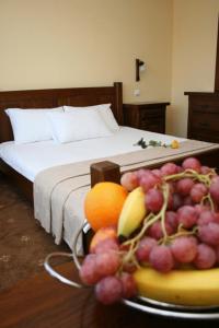 a bowl of fruit on a table next to a bed at Complex Casa Lux in Botoşani