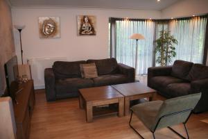 Susteren的住宿－Limburg-Chalet，客厅配有沙发和桌子