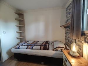 a bedroom with a bed and a brick wall at Limburg-Chalet in Susteren