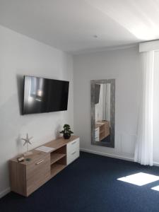 ein Wohnzimmer mit einem TV an einer weißen Wand in der Unterkunft Mediterrâneo Madeira in São Vicente