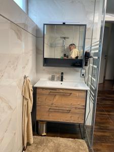 un hombre tomando una foto de un lavabo de baño en Appartement Architektenhaus - Pool - Fernsicht, en Lannach