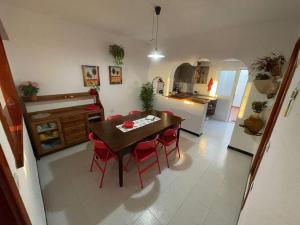 cocina y comedor con mesa y sillas rojas en Casa Leyna, en El Golfo