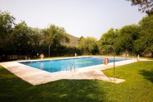 a swimming pool in a grassy field with at Bungalows Camping Jimmy Jones in Villaviciosa de Córdoba