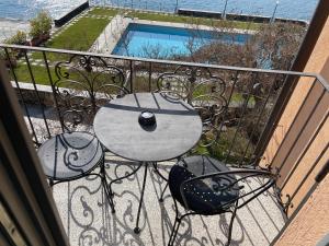 a table and chairs on a balcony with a pool at Hotel San Rocco in Orta San Giulio