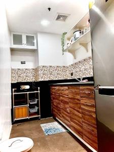 uma cozinha com um lavatório e um frigorífico em Legarse Staycation at Montecito Residential Resort em Manila