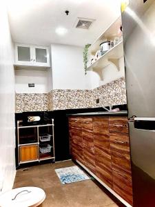 a kitchen with a sink and a refrigerator at Legarse Staycation at Montecito Residential Resort in Manila