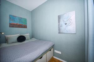 een slaapkamer met een bed en twee schilderijen aan de muur bij City Center Studio - Comfy & Modern in Bratislava