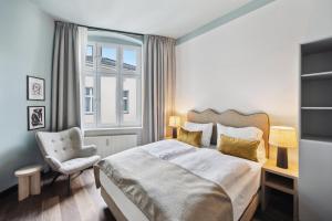 um quarto com uma cama, uma cadeira e uma janela em limehome Berlin Stresemannstr em Berlim