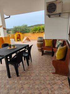 um pátio com uma mesa, cadeiras e um sofá em La_casa_di_ Willy em Canai